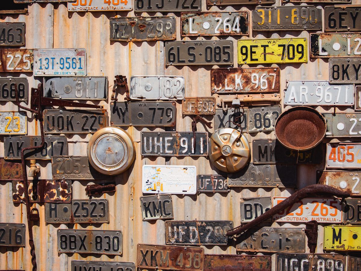 Un mur de plaques d’immatriculation anciennes et patinées.